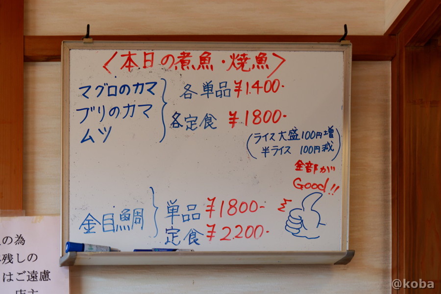 壁にかけられたホワイトボード、本日の煮魚・焼き魚のメニュー