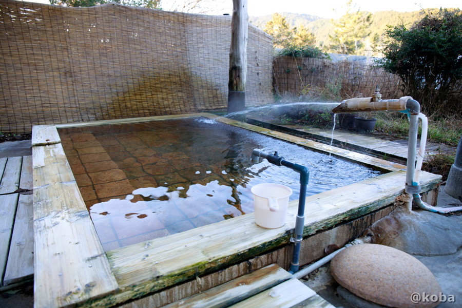 奥側の浴槽、目線を遮るようにすだれの塀が並ぶ露天風呂