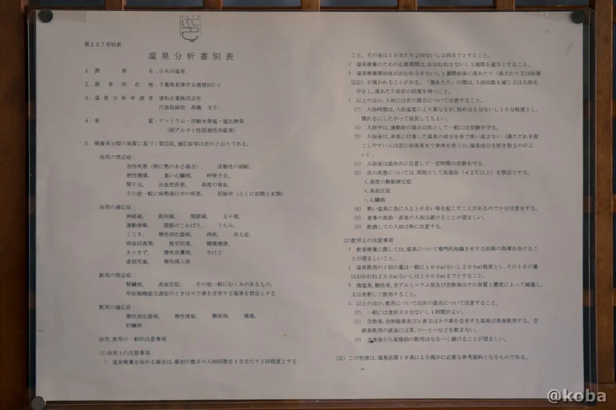 ホール横、に掲示された、小糸川温泉の天然黒湯の効能を証明する温泉分析書の写真。