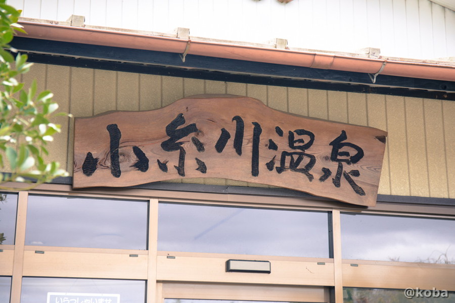 木製でレトロな雰囲気が漂う、「小糸川温泉」の看板の写真。