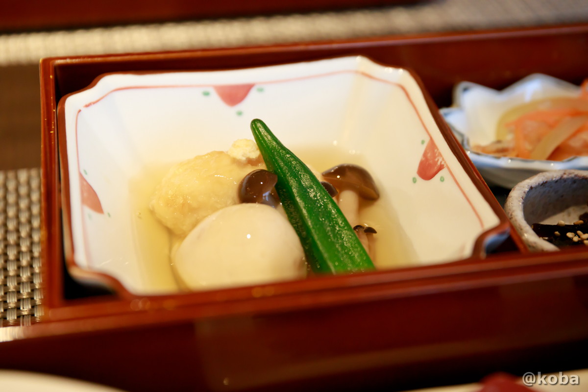 ホテルハーヴェスト勝浦の夕食で提供された、もちもちとした食感が美味しい馬鈴薯饅頭と、里芋、しめじ、オクラが添えられた温物の写真。