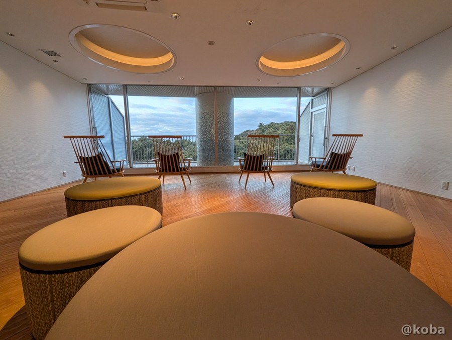 ホテルハーヴェスト勝浦の大浴場にある、丸いソファやゆったり座れるイスが並んだ湯上がりラウンジの写真。