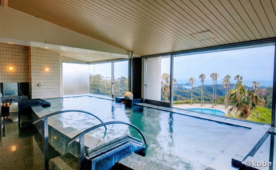 ホテルハーヴェスト勝浦の客室モニターに映し出された、大きなガラス窓から景色が楽しめる広々とした大浴場の施設紹介画像。