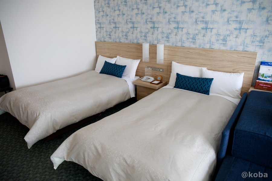 ホテルハーヴェスト勝浦の10階客室(スタンダード洋室)に並ぶ、清潔なツインベッドの写真。