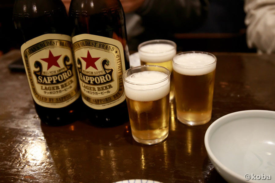 サッポロラガー瓶ビール「赤星」と、冷えたビールがたっぷりと注がれた3つのグラス