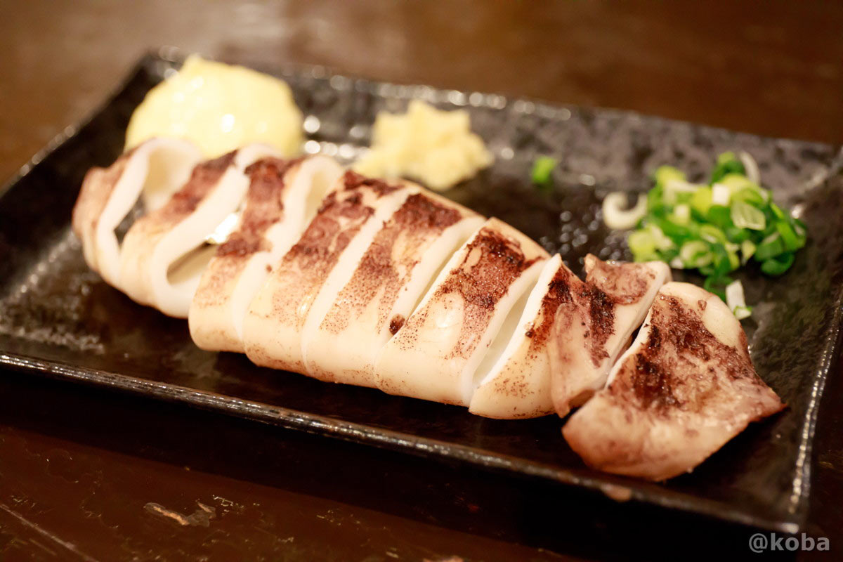 こんがりと香ばしく焼かれたイカ焼き。マヨネーズや生姜、刻みネギの薬味が添えられた食欲をそそる一皿