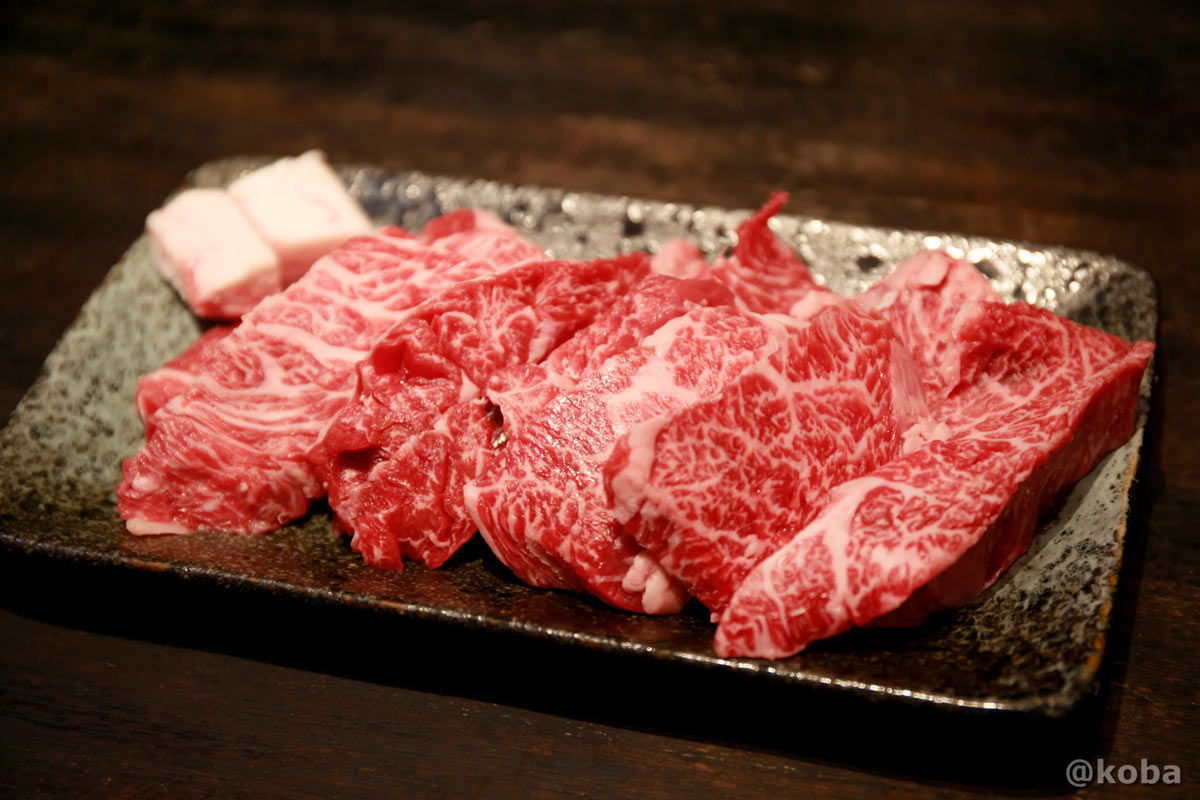 藤森畜産(葛飾区西水元)で購入した国内産牛上カルビ。きめ細やかな霜降りが美しく、厚切りにされた上質な牛カルビが牛脂と共に和皿に並んでいる様子