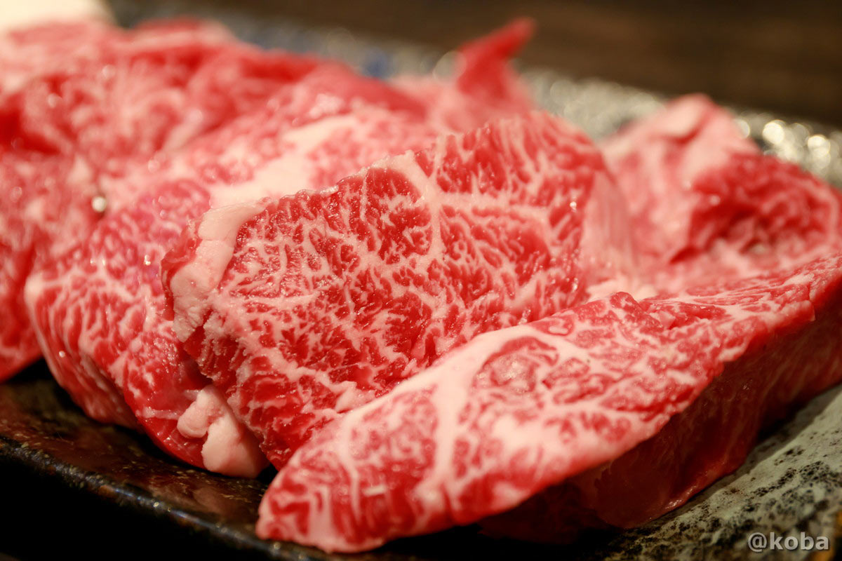 藤森畜産(葛飾区西水元)の国内産牛上カルビのアップ。きめ細やかなサシ(霜降り)と鮮やかなお肉の色味が美しく、とろけるような質感が伝わる精肉の接写写真