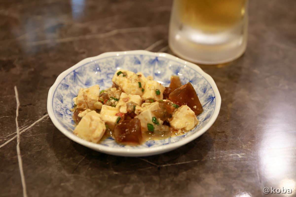 お通しとして提供された豆腐とピータンの和え物