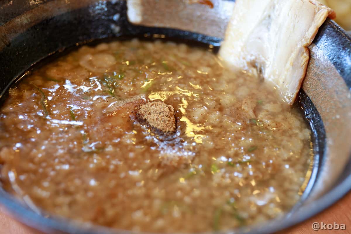 魚粉がトッピングされた濃厚な魚介豚骨のつけ汁