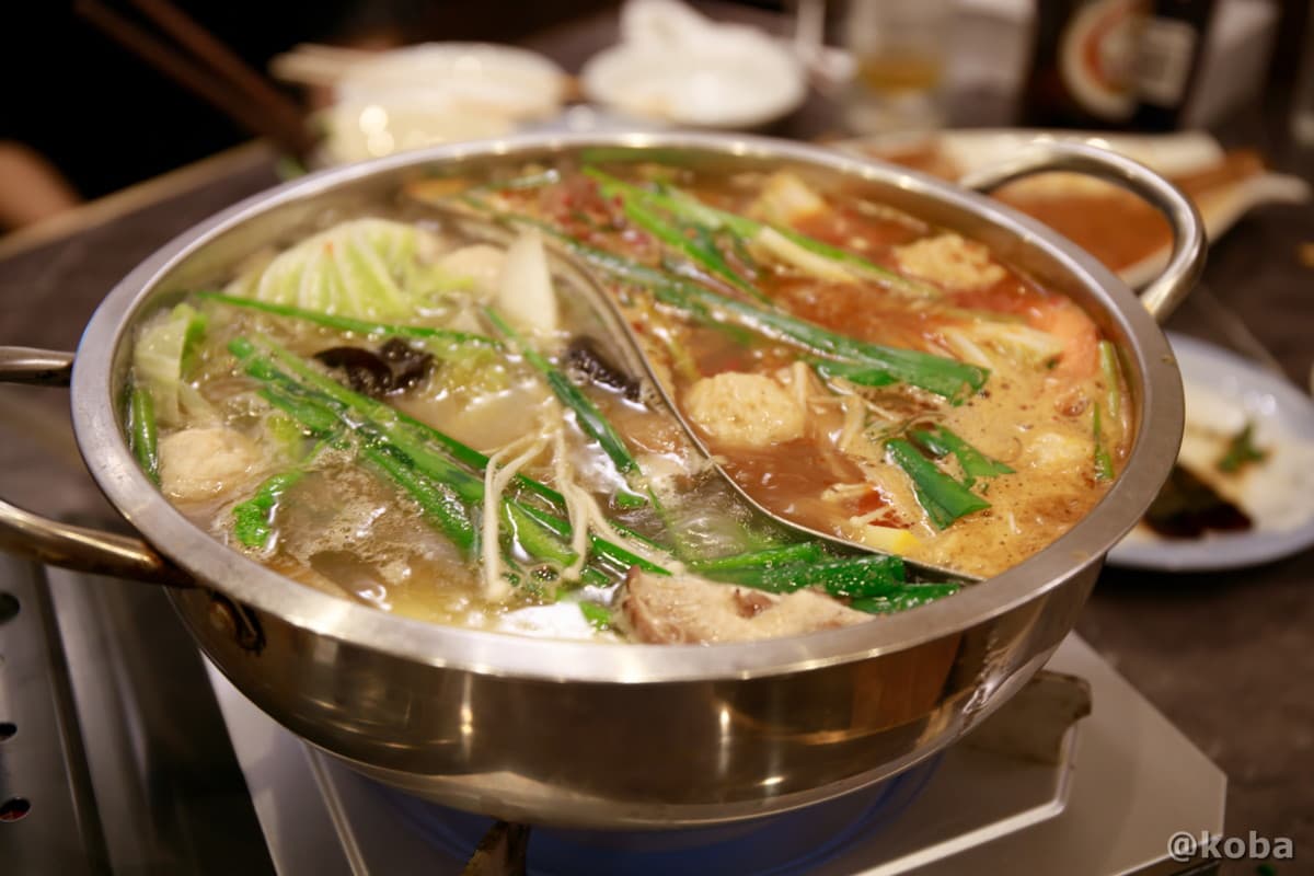 野菜や肉団子がたっぷりと煮込まれ、湯気を立てている熱々のダブル火鍋